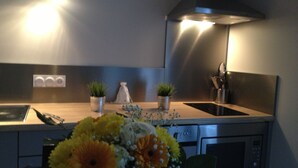 A kitchen with a wooden countertop, two potted plants, a sink, and a microwave. - Demeure et Dependance (Tassin-la-Demi-Lune)