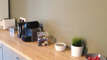 A kitchen counter with a toaster, coffee maker, and a small potted plant.