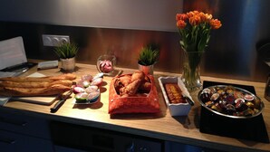 A kitchen counter with various baked goods, a laptop, and decorative items. - Demeure et Dependance (Tassin-la-Demi-Lune)