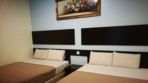 Quarto de hotel com duas camas de solteiro, cada uma com colcha marrom e almofadas brancas, e um quadro grande de flores na parede.