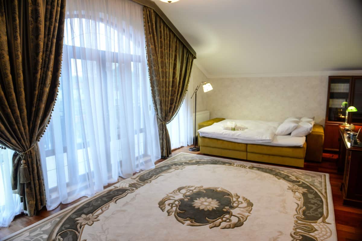 Una habitación de hotel con una cama grande, un sofá, un escritorio y una lámpara.