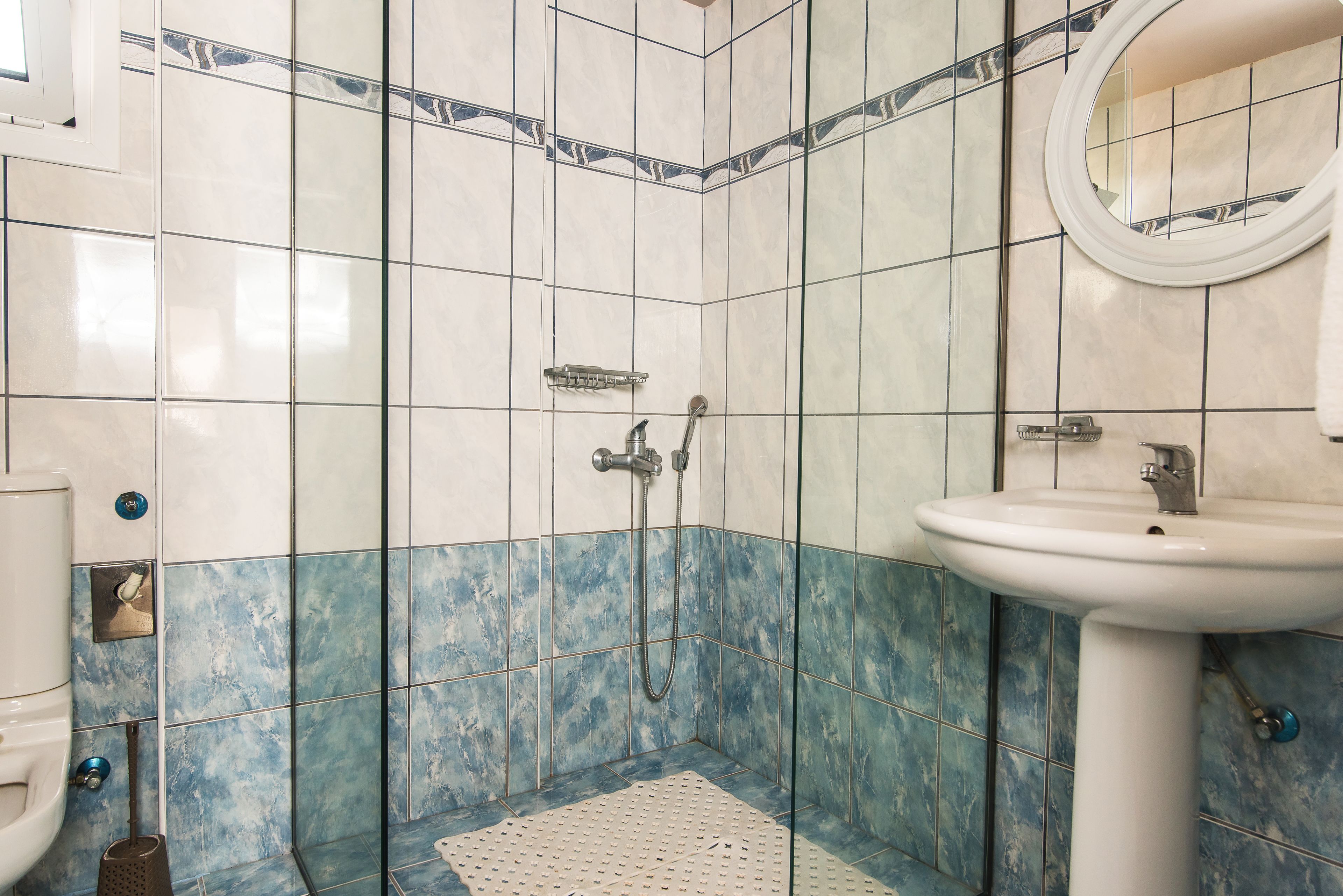 A bathroom with a shower, a sink, and a toilet.