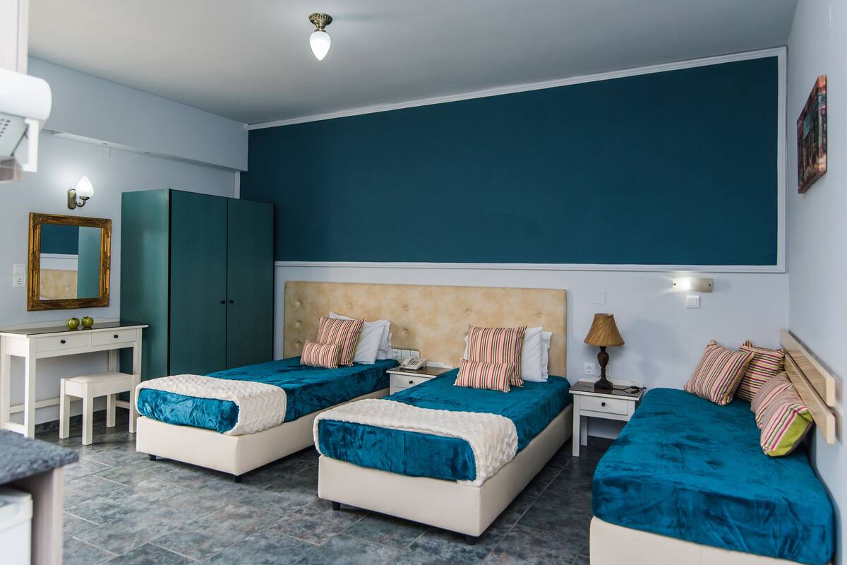 Een hotelkamer met twee bedden, een bureau, een kledingkast en een grote spiegel.