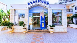 A reception area with a clear glass entrance, AT&T branding, and potted plants. - Yiannis Manos (Hersonissos)