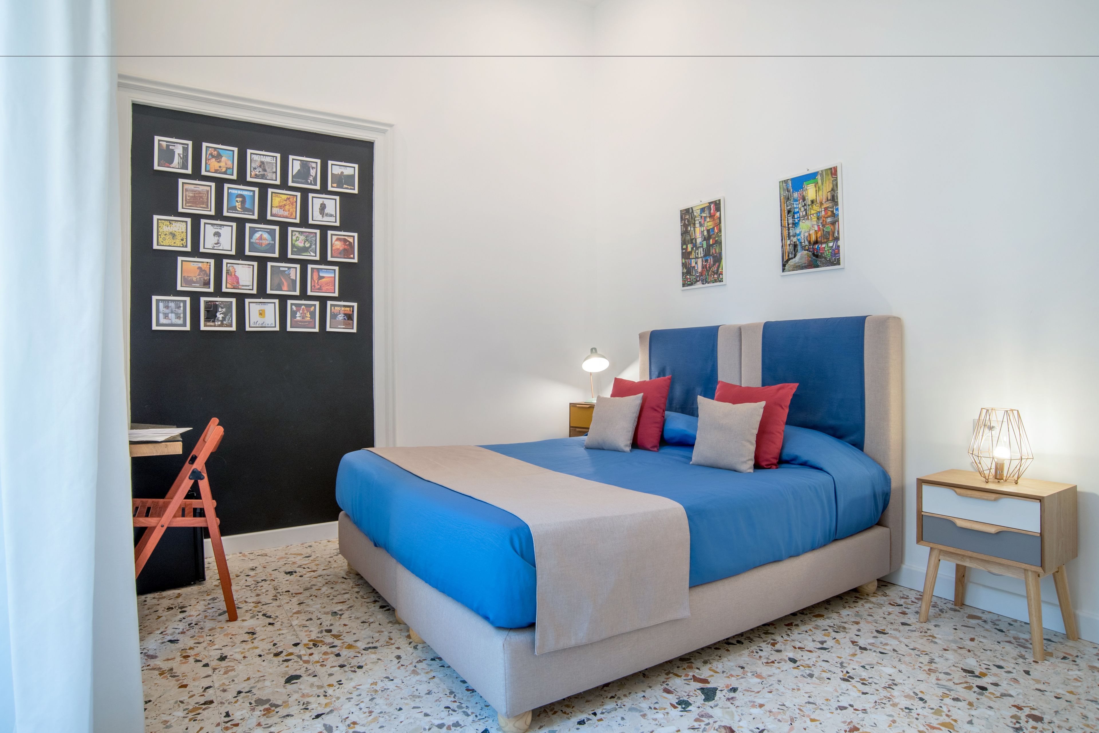 A bedroom with a bed, a desk, and a chair.
