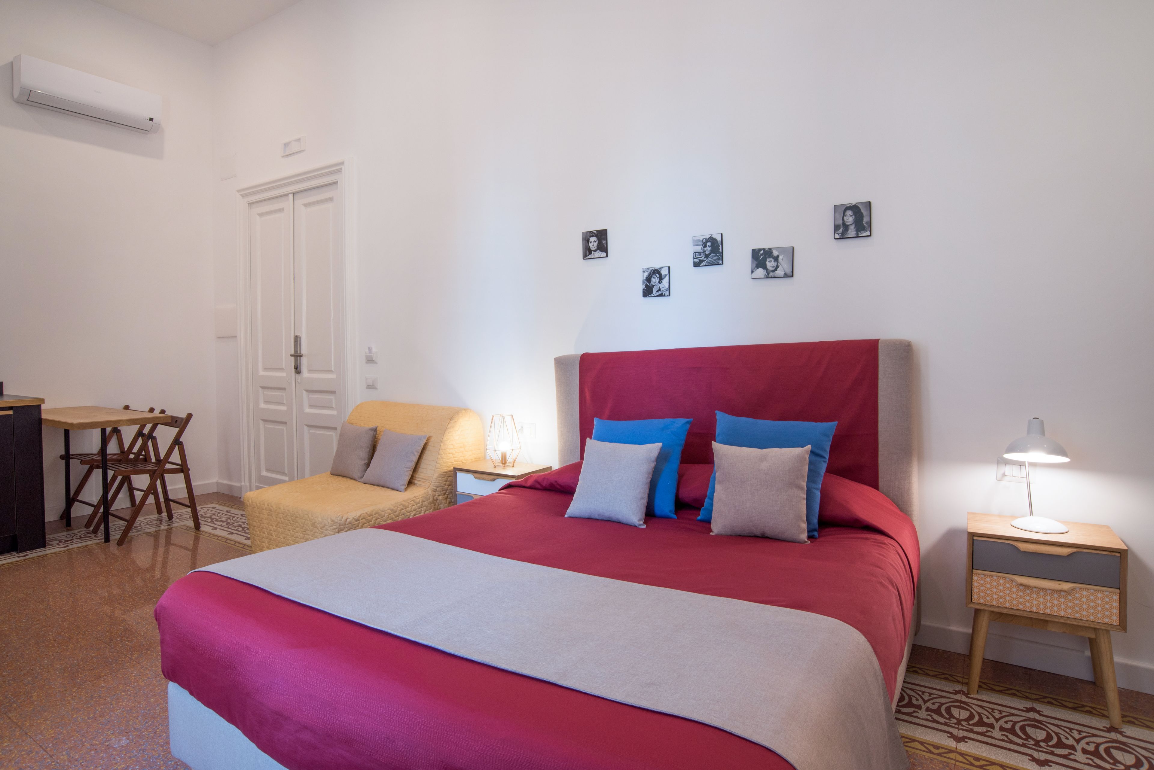 Une chambre bien rangée, avec un grand lit, un bureau et une chaise.