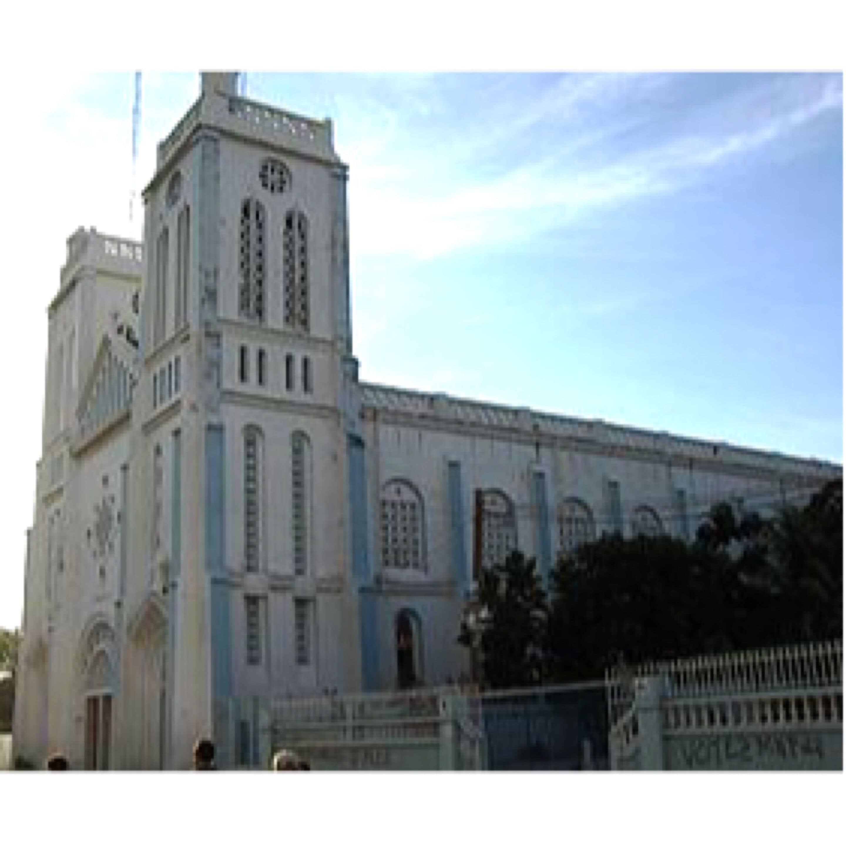 A large, historic building with a prominent tower and arched windows.