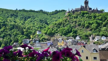 A historic castle on a hill with colorful buildings below.