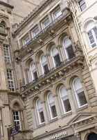 A historic building with ornate architectural details, including arched windows and decorative stonework.