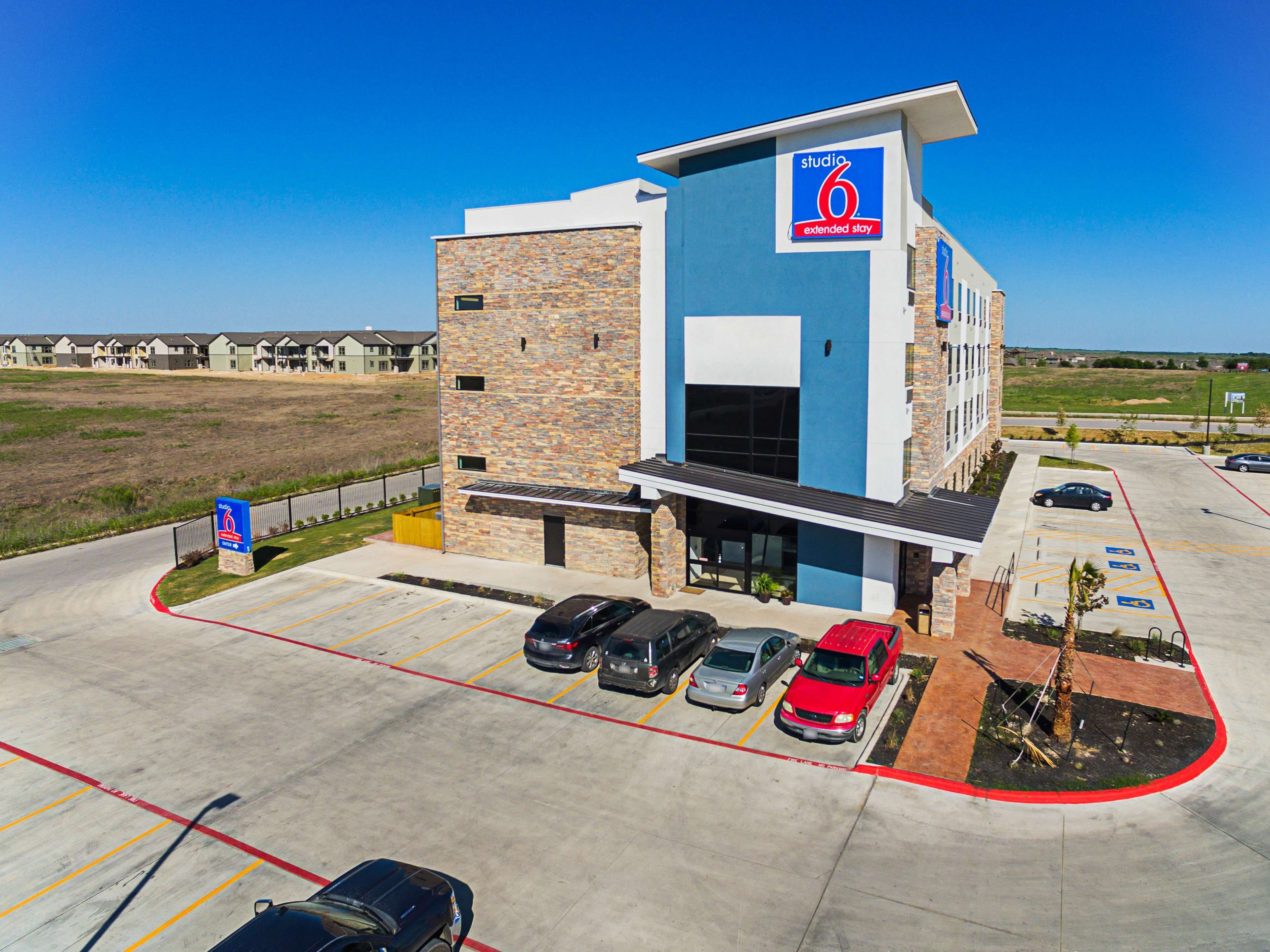 A modern building with a sign for 'Studio 6 Extended Stay'.