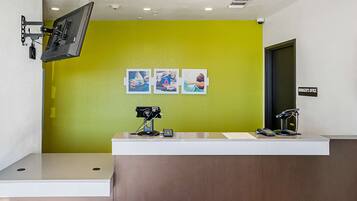 A reception desk with a mounted camera, a security camera, and a sign indicating the manager's office.