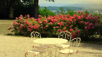 A round table with four chairs in a garden setting.