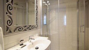 A modern bathroom with a white sink, a large mirror, and a glass-enclosed shower. - Hostal los Castañuelos (Candeleda)