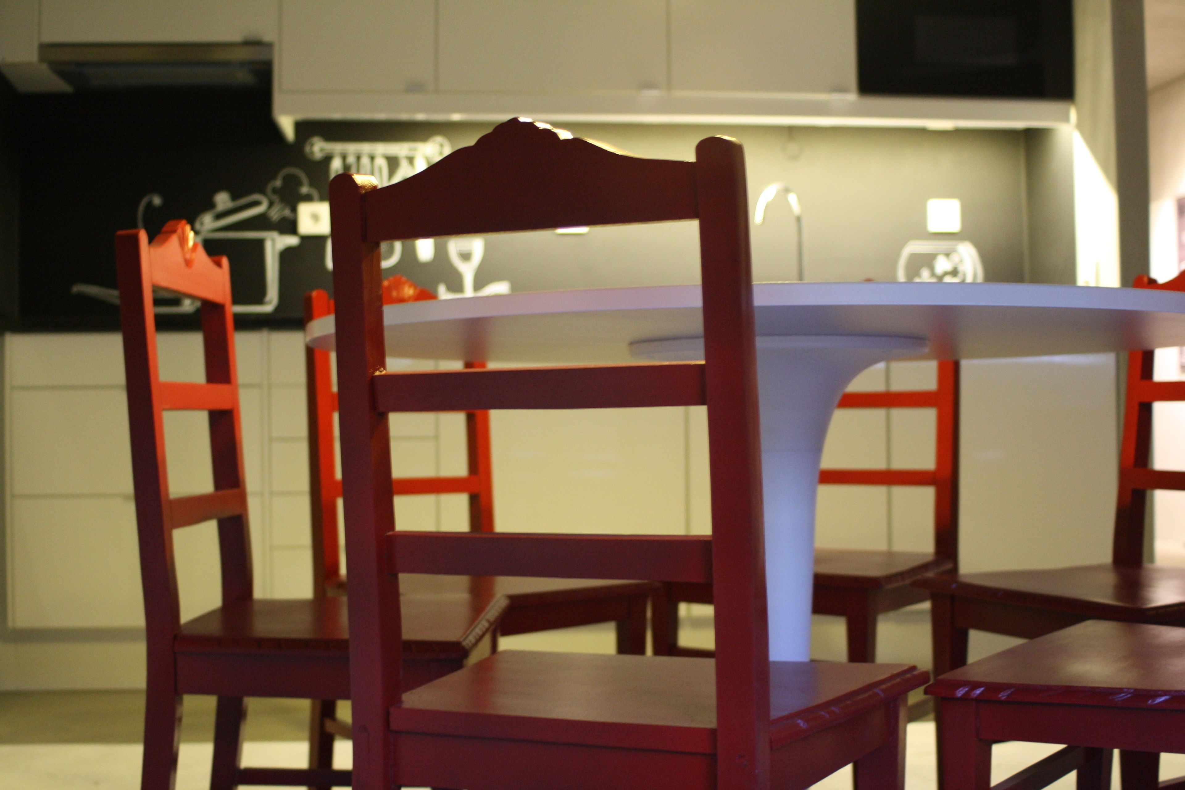 A dining area with a round table and four wooden chairs.
