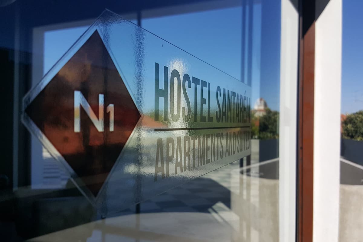En skylt för ”Hostel Santa Creu Apartments and Suites” med en tydlig vy över den omgivande arkitekturen.