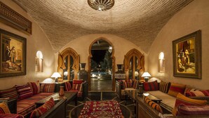 Un hall d’entrée luxueux, agrémenté d’arcs décoratifs, de sièges confortables et offrant une vue sur un élément aquatique.