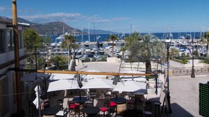 A marina with boats, outdoor seating, and a view of the sea. - Hôtel l'Oursin (Saint-Jean-Cap-Ferrat)