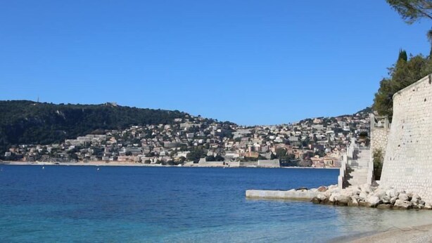 A coastal town with a stone wall and a clear blue sea. - Hôtel l'Oursin (Saint-Jean-Cap-Ferrat)