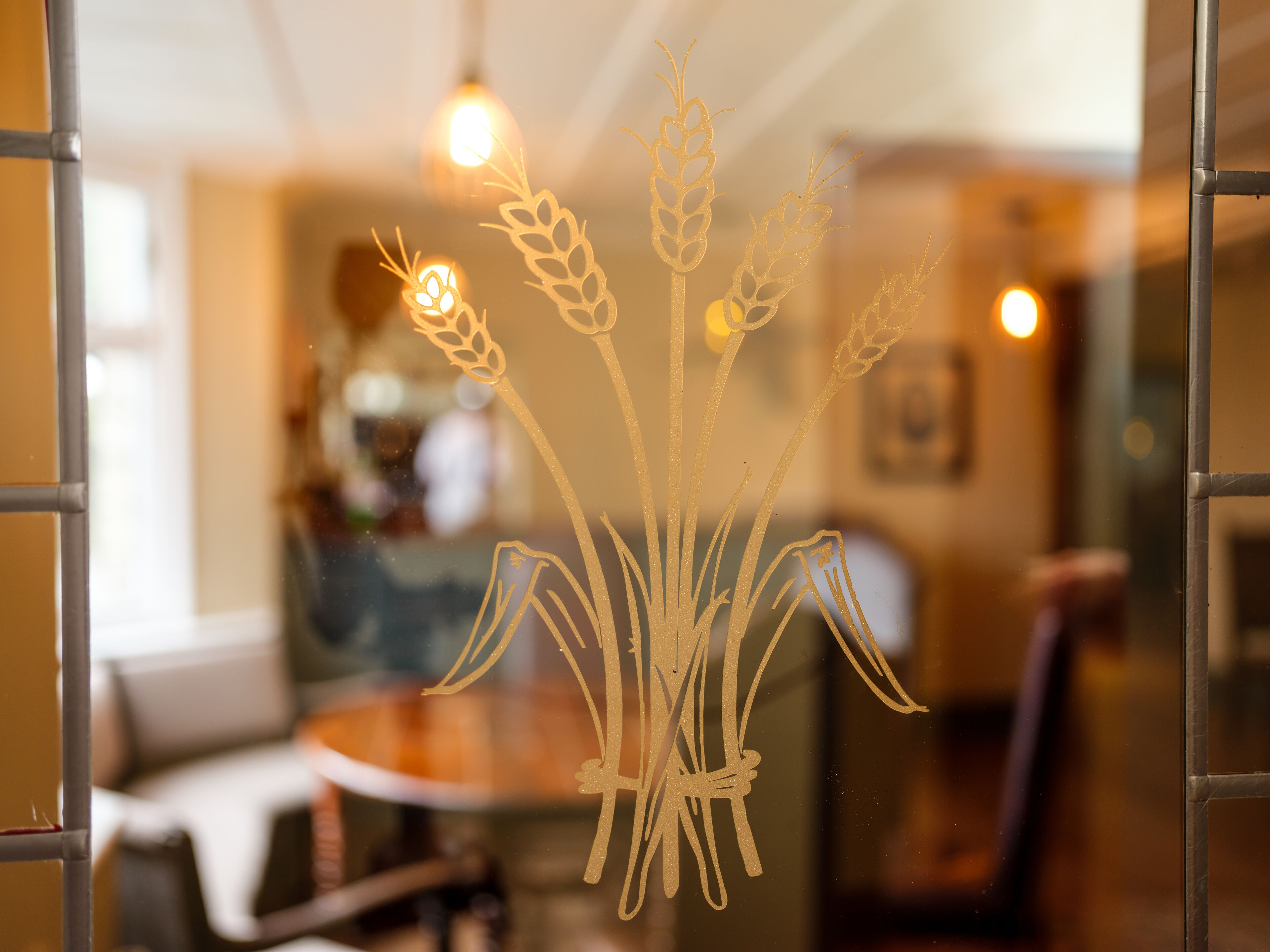 A window with a decorative wheat design.