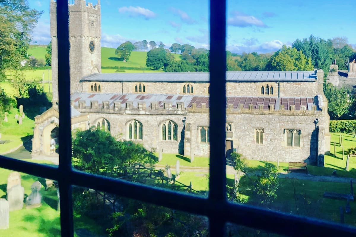 A historic building with a prominent tower, arched windows, and a courtyard.