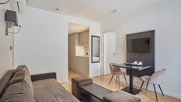 Una sala de estar moderna con un sofá, una mesa de centro y un televisor montado en la pared.