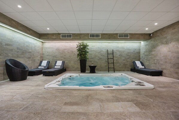 A spa area with a hot tub, lounge chairs, and a potted plant. - Appart Hotel Odalys City Paris Montmartre (Paris)