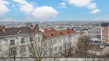 A cityscape with historic buildings and modern skyscrapers under a clear sky.