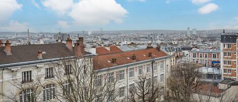 Een stadsbeeld met historische gebouwen en moderne wolkenkrabbers onder een heldere lucht.