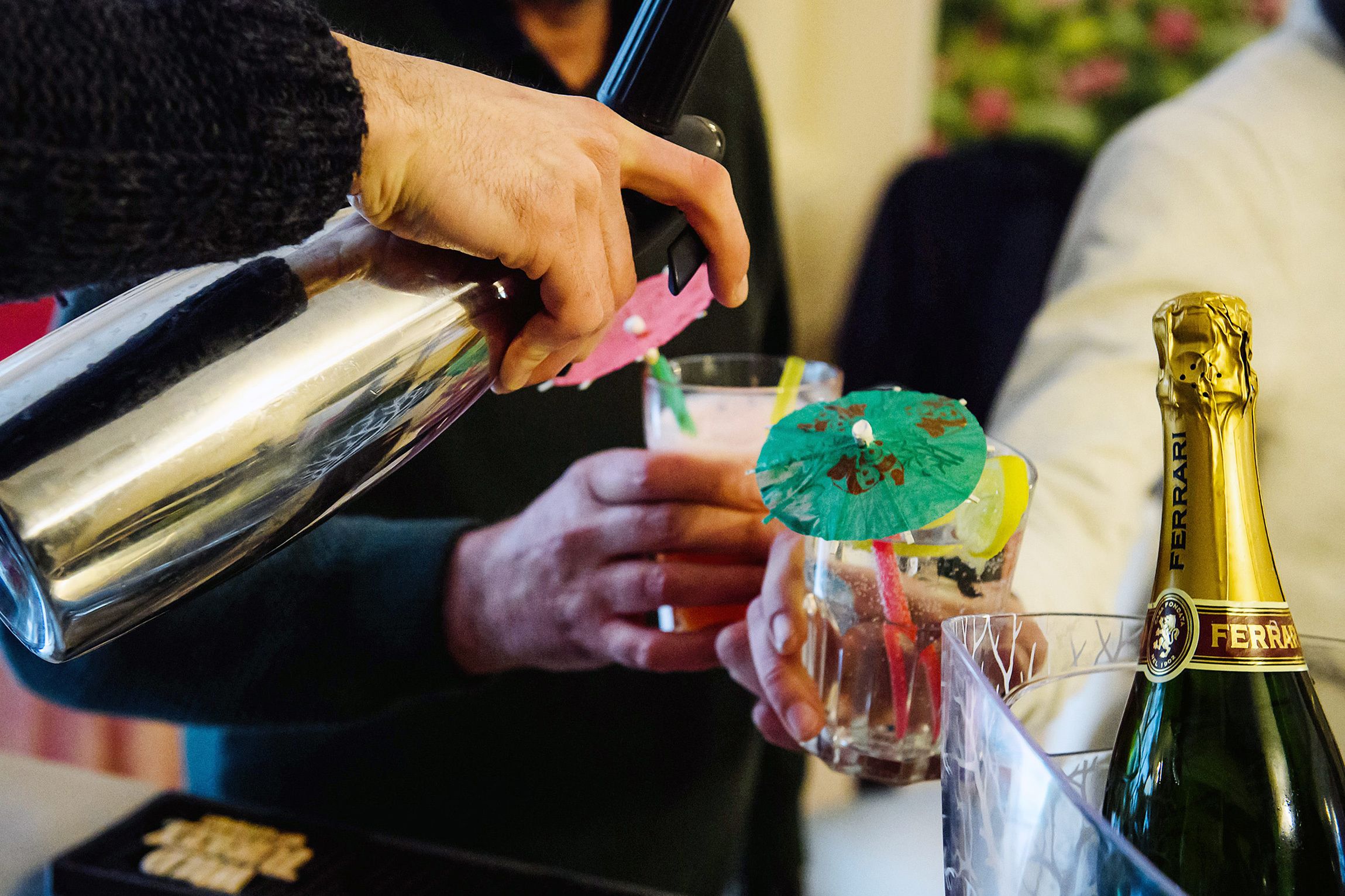 A person pouring a drink from a bottle into a glass.