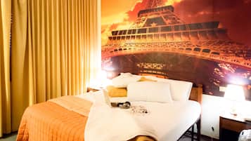 A hotel room with a bed, a laptop, and a picture frame on the bed.