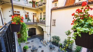 A courtyard with outdoor seating, potted plants, and a bicycle. - Josephine Old Town Square Hotel - Czech Leading Hotels (Prague)