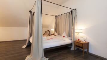 A four-poster canopy bed with a wooden nightstand beside it.