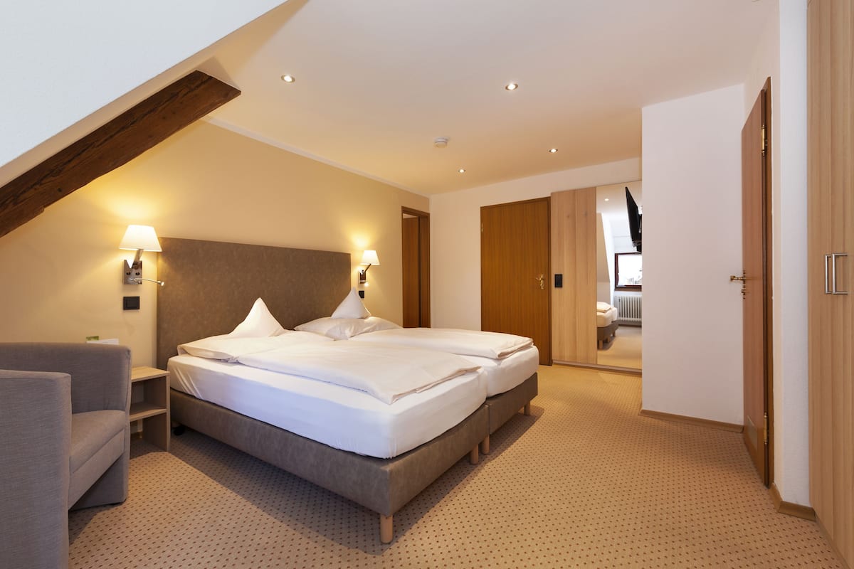 Una habitación de hotel moderna con una cama grande, un sofá y un escritorio.