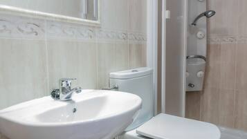 Een badkamer met een wastafel, toilet en douche.