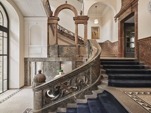 Un magnifique escalier en marbre, à marches incurvées, menant à un niveau supérieur.