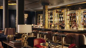A bar area with a bartender, bar stools, and a well-stocked liquor shelf.