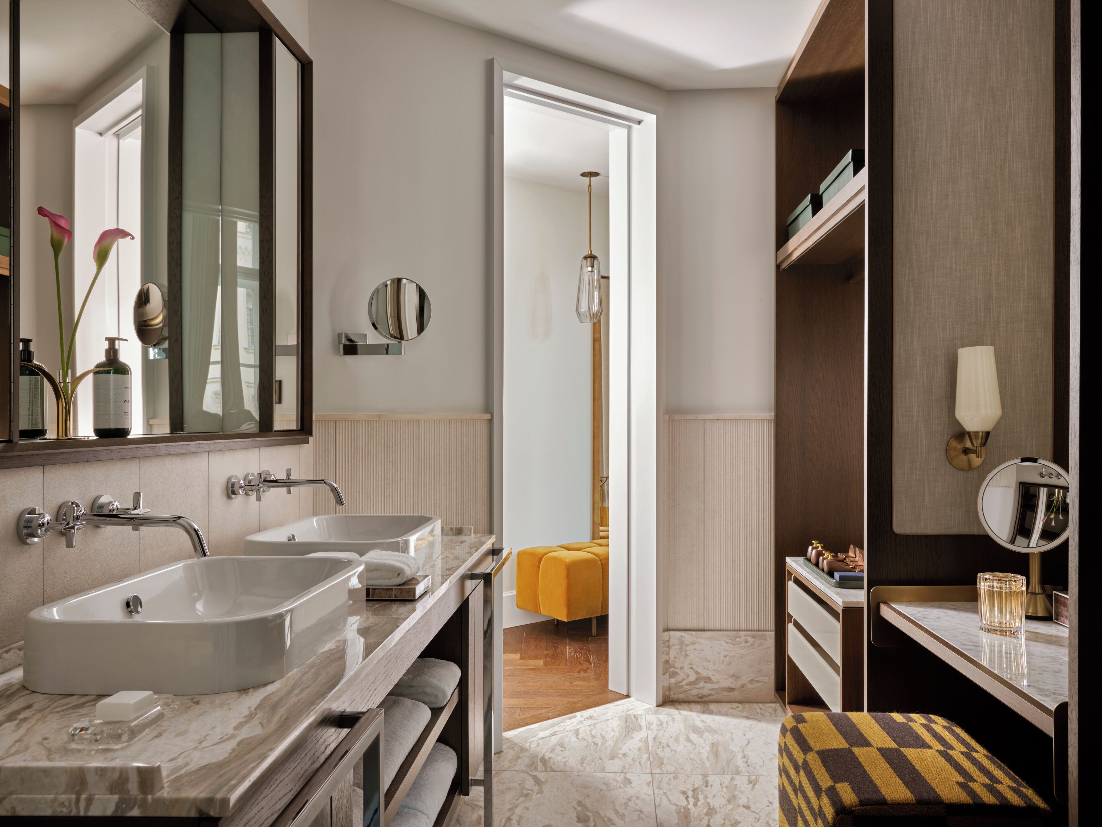 Un baño moderno con dos lavamanos, un espejo, toallero y cabina de ducha.