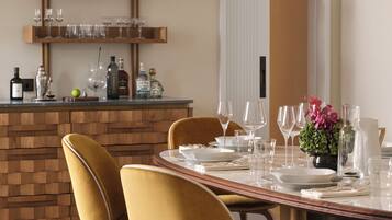 A dining area with a wooden table, two chairs, and a hanging light fixture.