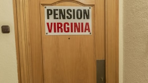 Una puerta de madera con un letrero que dice "PENSION VIRGINIA".