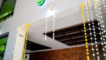 Een hotel lobby met een modern ontwerp, inclusief een receptiebalie, een zithoek en een bord met Hotel Brisas Express.