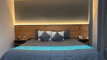 A bedroom with a bed, headboard, bedside tables, and a nightstand.