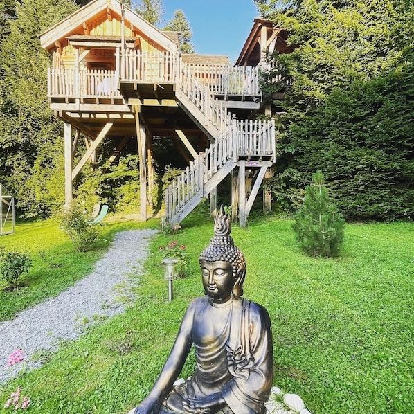 A wooden structure with a balcony and stairs, surrounded by greenery. - Les Lodges de Babylone (Larringes)