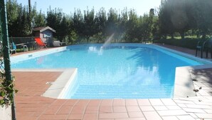 A rectangular swimming pool with a clear blue water surface, surrounded by a tiled deck. - Agriturismo La Praduscella (Fivizzano)