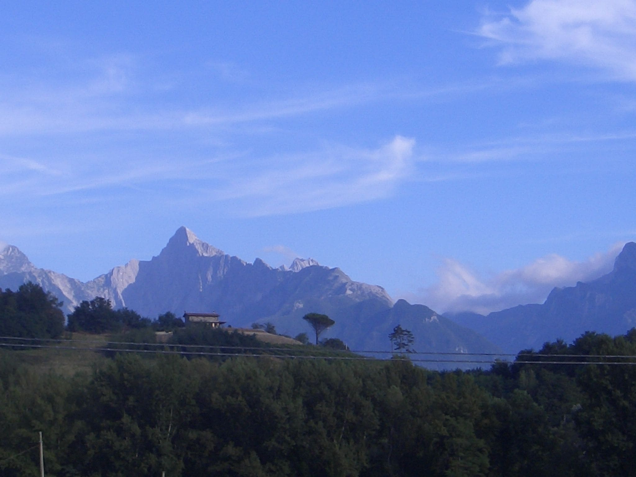 A mountain landscape with a building on a hill.