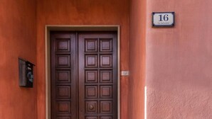 A double wooden door with a stone base and a number plaque indicating room 16. - B&B Su Connotu (Sestu)