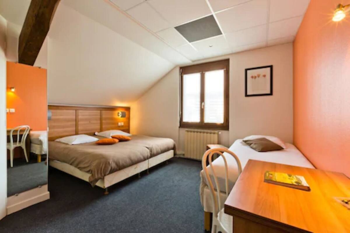 Una habitación pequeña y acogedora con una cama, un escritorio y una silla. Hay una ventana con persianas, un radiador y un cuadro en la pared.