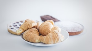A plate with croissants and a chocolate-covered pastry. - B&B La Postale (San Salvo)