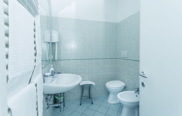 Un baño con lavamanos, inodoro y bidé.