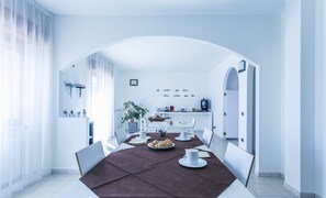 Un comedor moderno con una mesa larga, sillas y una máquina de café.