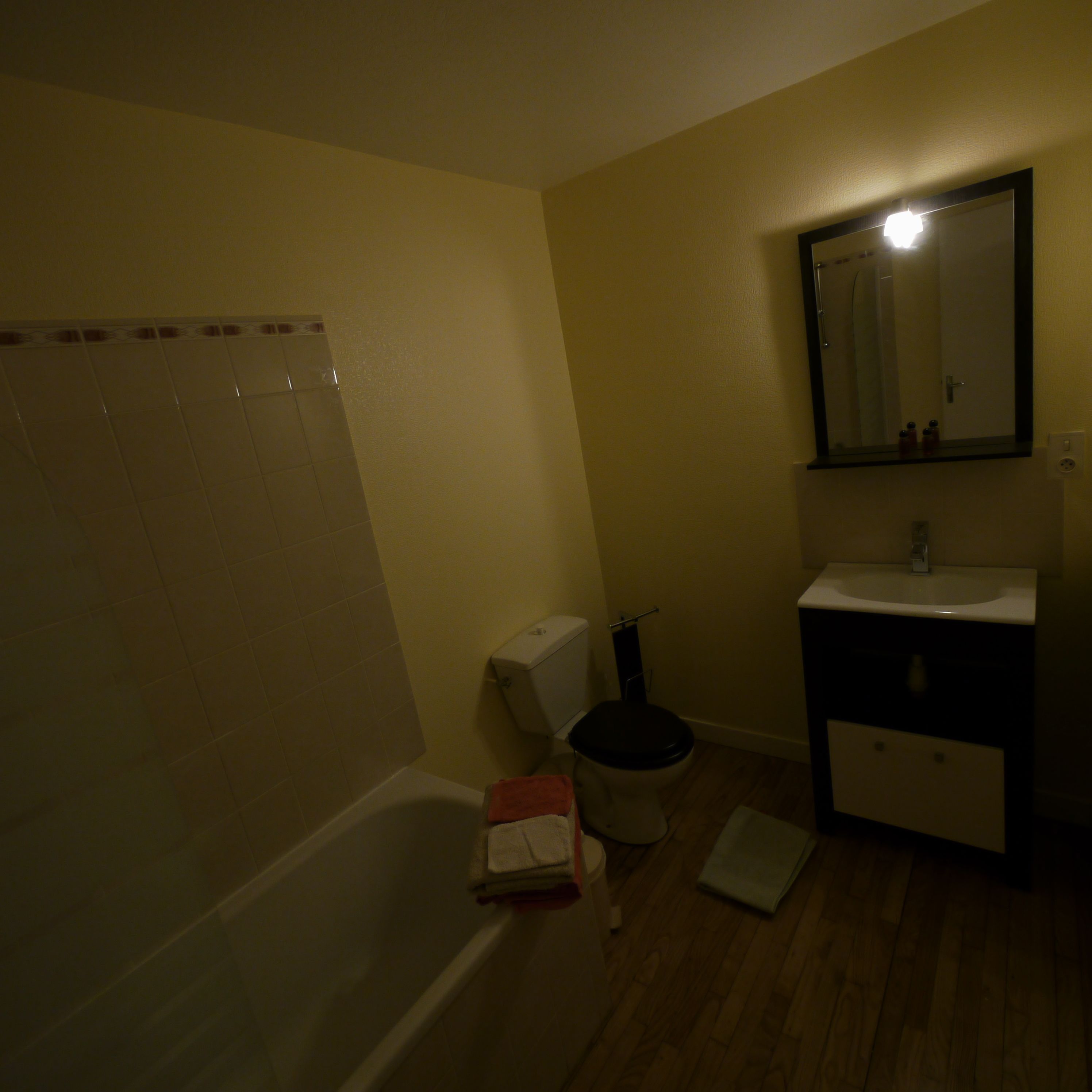 Een kleine badkamer met toilet, wastafel en bad.
